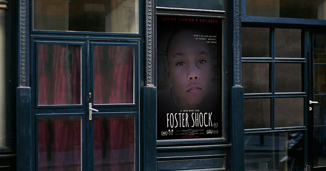A view of a Foster Shock poster hung outside a windowed office district.